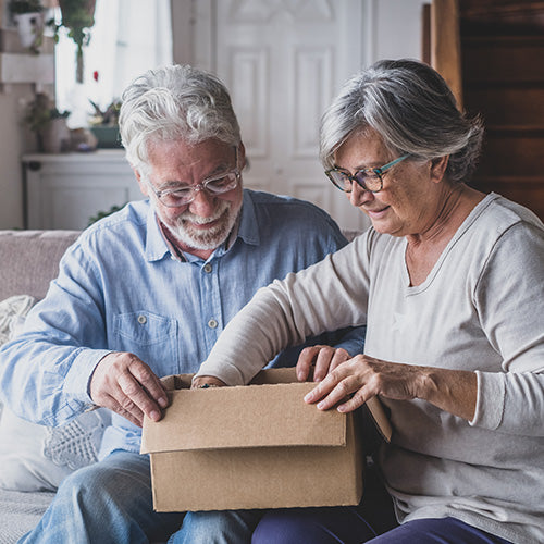 A pair of gardeners open a gift from their loved ones.