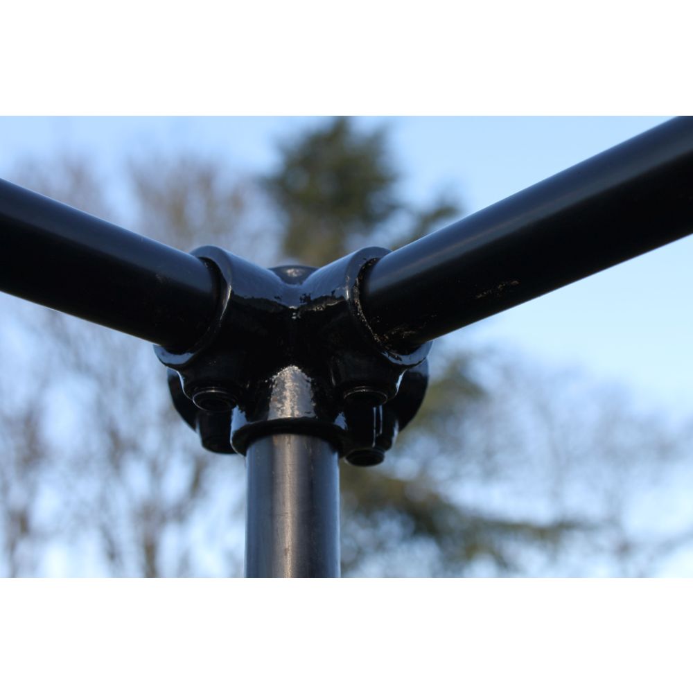Close-up of a black metal pipe with a blurred natural background
