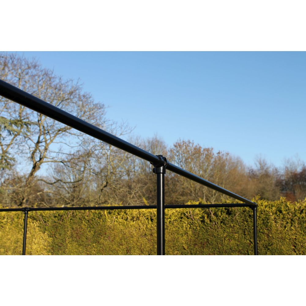 Black metal fence with trees and blue sky in the background